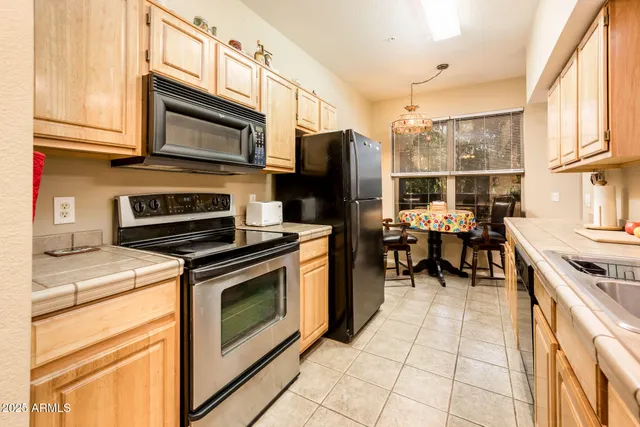 a kitchen with stainless steel appliances granite countertop a stove refrigerator and a microwave