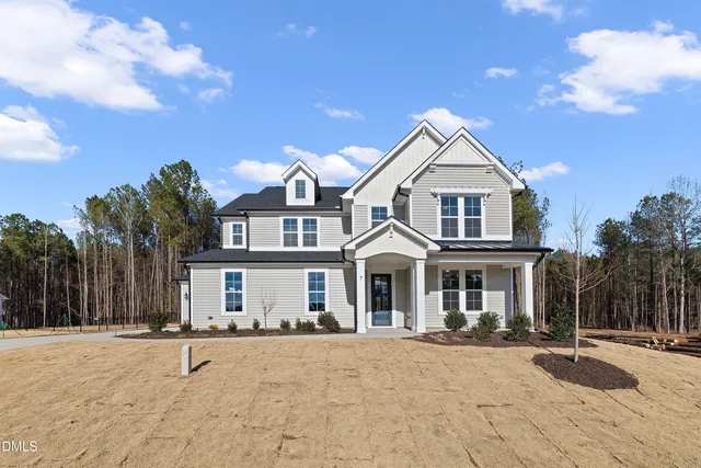 a front view of a house with yard and trees