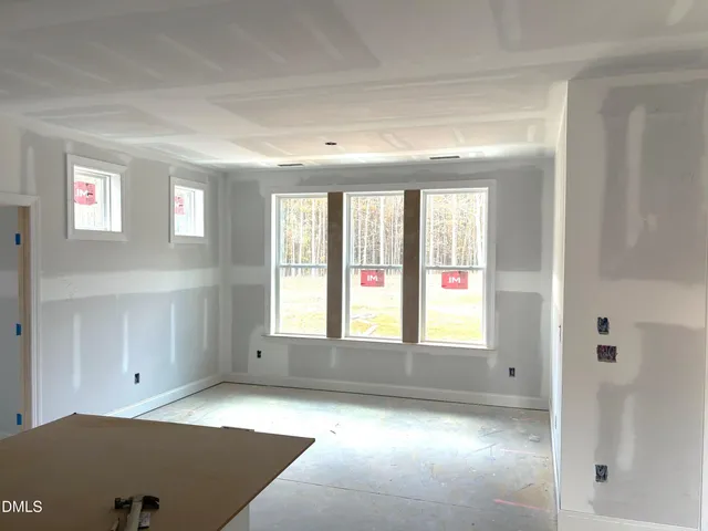 a large white kitchen with kitchen island a sink wooden floor and stainless steel appliances