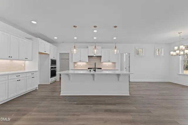 an empty room with windows and ceiling fan