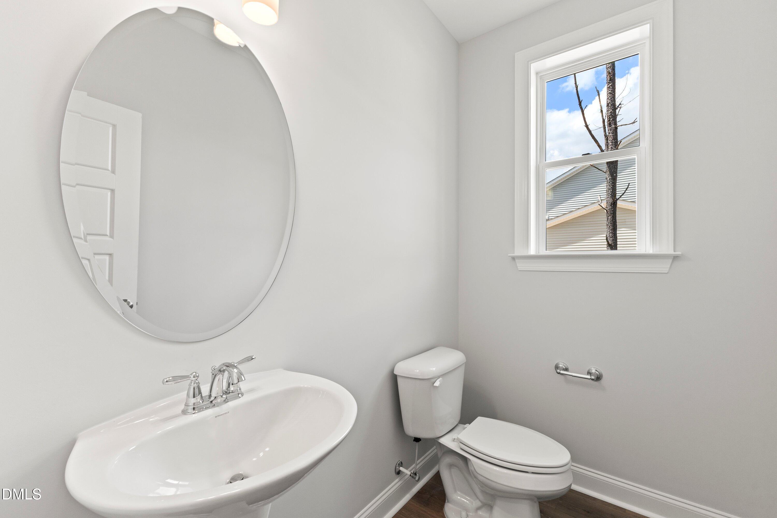 7 East Victoria Ridge Drive, Unit 16 Selma, NC 27576 - Photo 22 of 45 a bathroom with a toilet a sink a mirror and a window