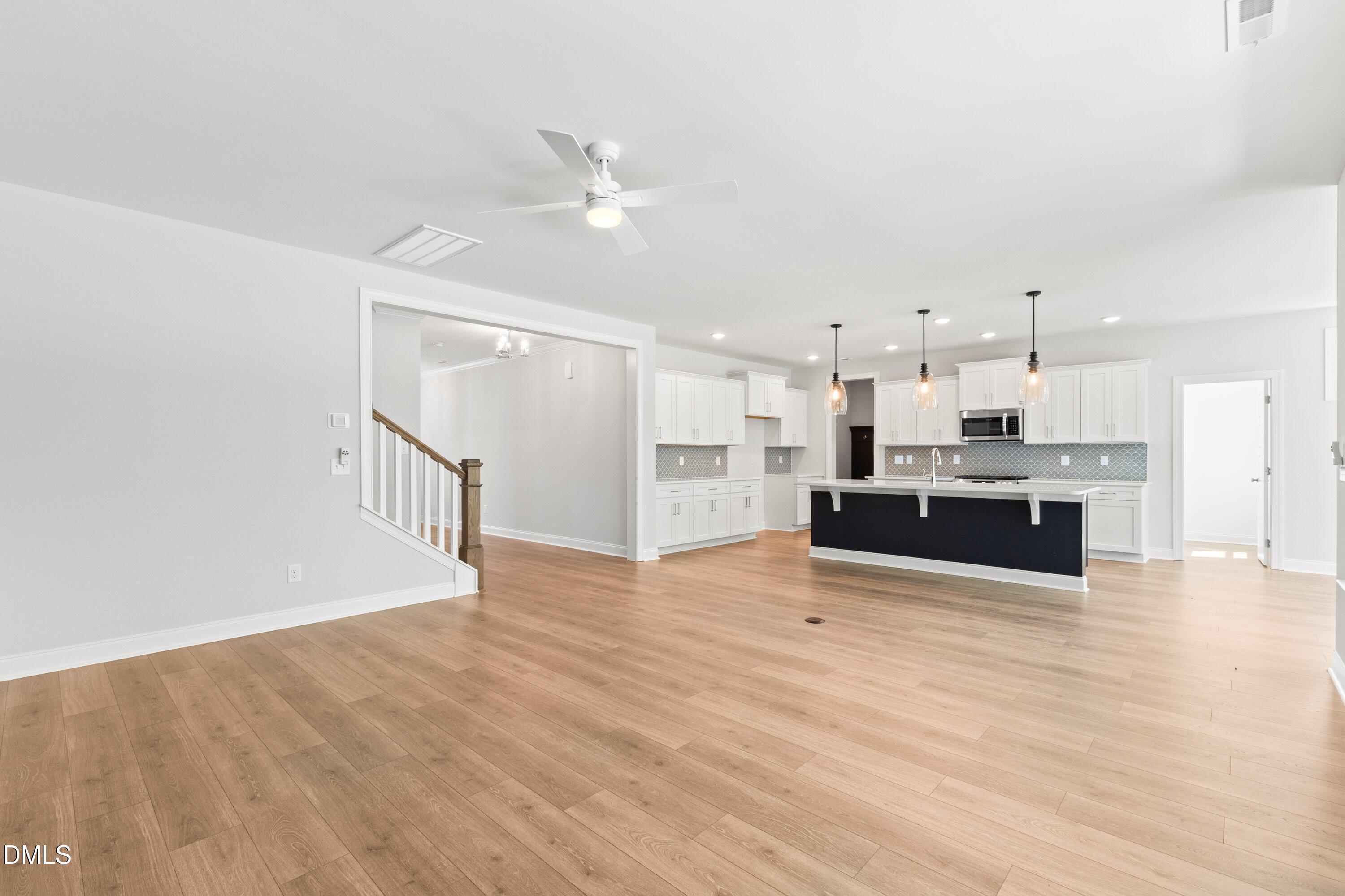 7 East Victoria Ridge Drive, Unit 16 Selma, NC 27576 - Photo 27 of 45 a large white kitchen with kitchen island a sink wooden floor and stainless steel appliances