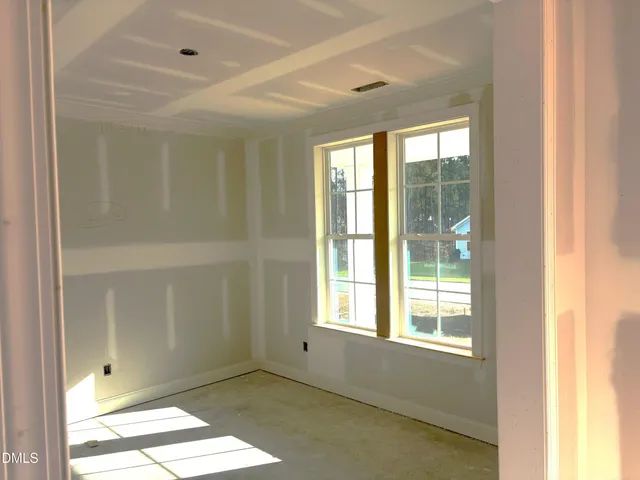 a view of an empty room with wooden floor fireplace and a window