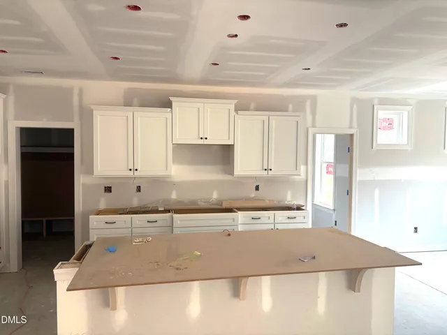 a view of an empty room with wooden floor fireplace and a window