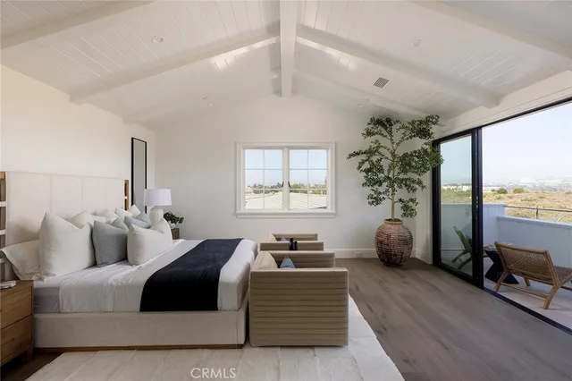 a bedroom with furniture and a large window
