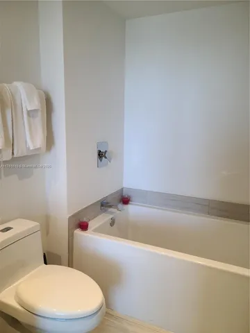 a white bath tub sitting next to a white toilet