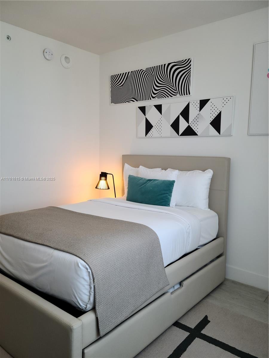 4010 South Ocean Drive, Unit R3309 Hollywood, FL 33019 - Photo 7 of 14 a bedroom with a bed and wooden floor