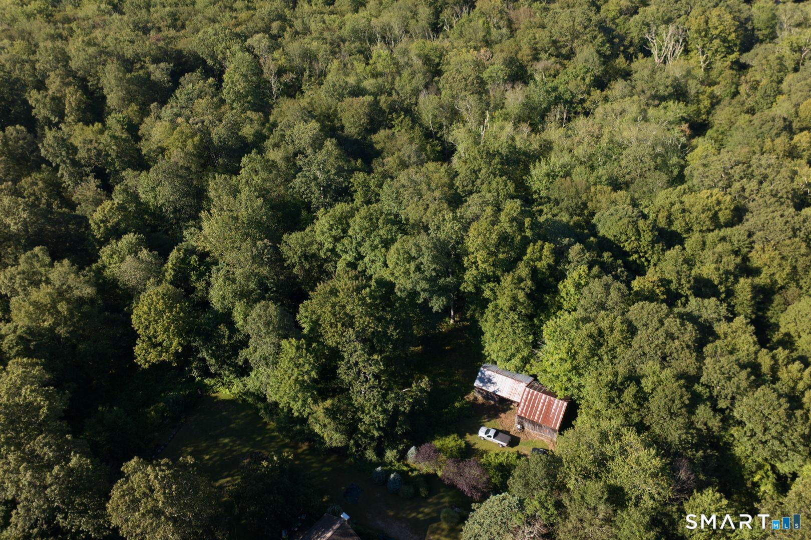 Aerial perspective highlighting the existing barn and surrounding acreage.