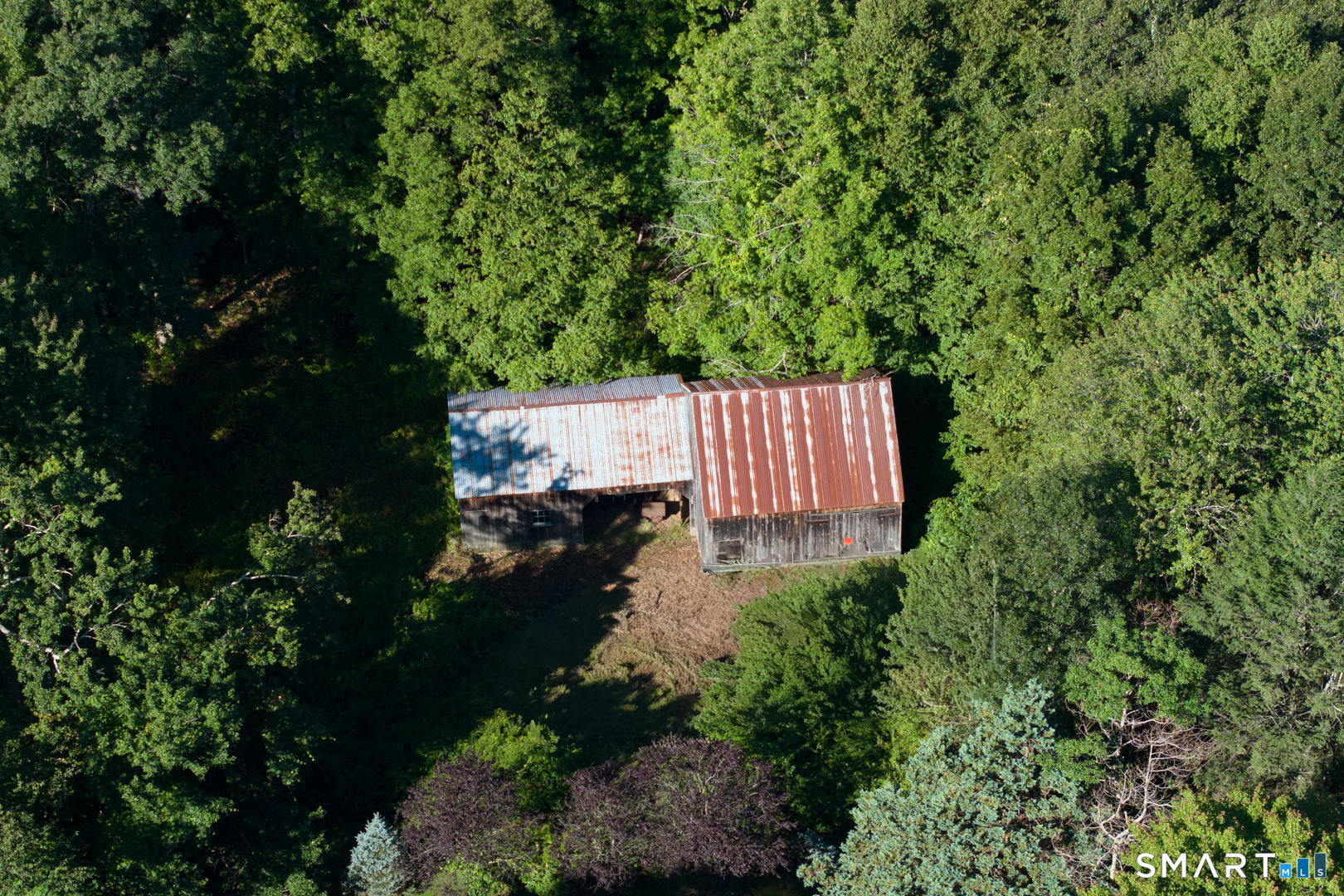335 Old Post Road Tolland, CT 06084 - Photo 7 of 13 Aerial perspective highlighting the barn within the surrounding wooded acreage.
