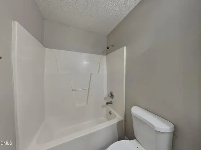 a white toilet sitting next to a bath tub