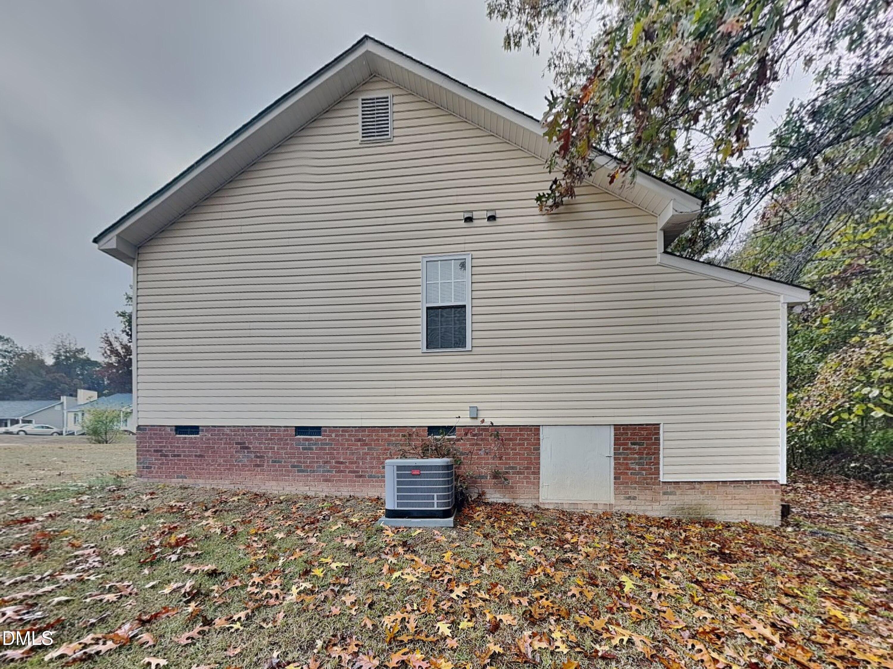 1017 Laurel Leaf Road Zebulon, NC 27597 - Photo 14 of 16 a view of a white house with a small yard and large tree