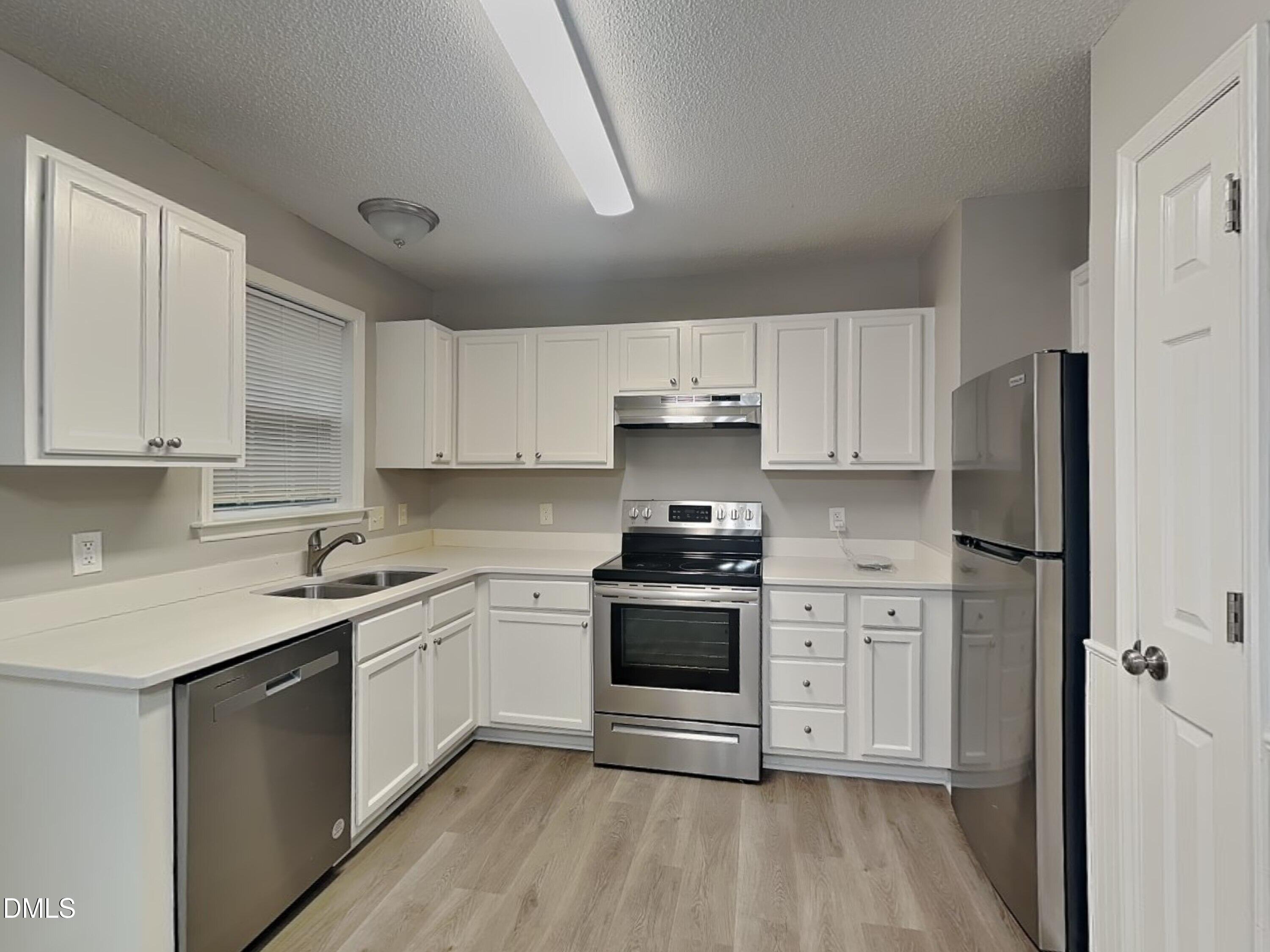 1017 Laurel Leaf Road Zebulon, NC 27597 - Photo 6 of 16 a kitchen with cabinets stainless steel appliances a sink and wooden floor