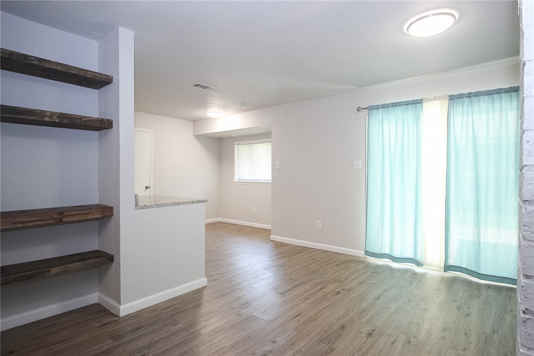 3720 Wingate Drive Waco, TX 76706 - Photo 9 of 18 an empty room with wooden floor and windows