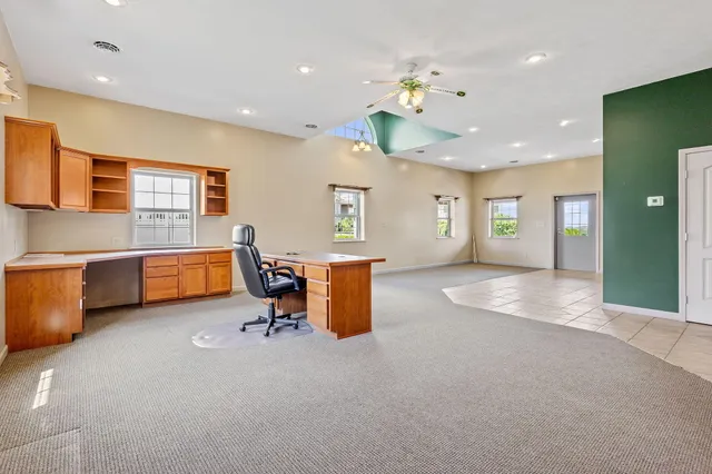 a large living room with stainless steel appliances kitchen island granite countertop furniture and a livingroom view