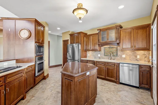 a kitchen with stainless steel appliances granite countertop a stove refrigerator and cabinets