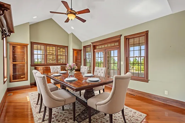 a dining room with furniture a chandelier and wooden floor