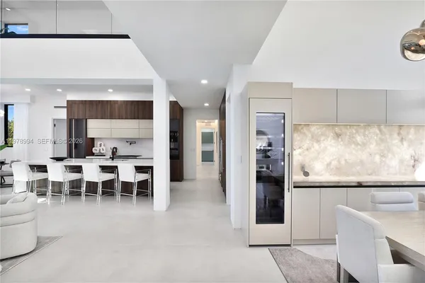 a kitchen with stainless steel appliances a sink a stove a refrigerator cabinets and a dining table