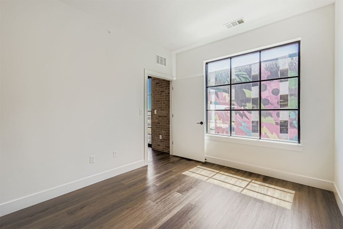 4315 South Congress Avenue, Unit 305 Austin, TX 78745 - Photo 11 of 14 an empty room with wooden floor and windows