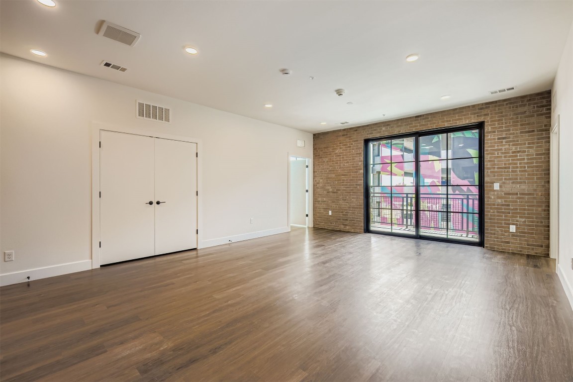 4315 South Congress Avenue, Unit 305 Austin, TX 78745 - Photo 5 of 14 a view of an empty room with wooden floor and a window