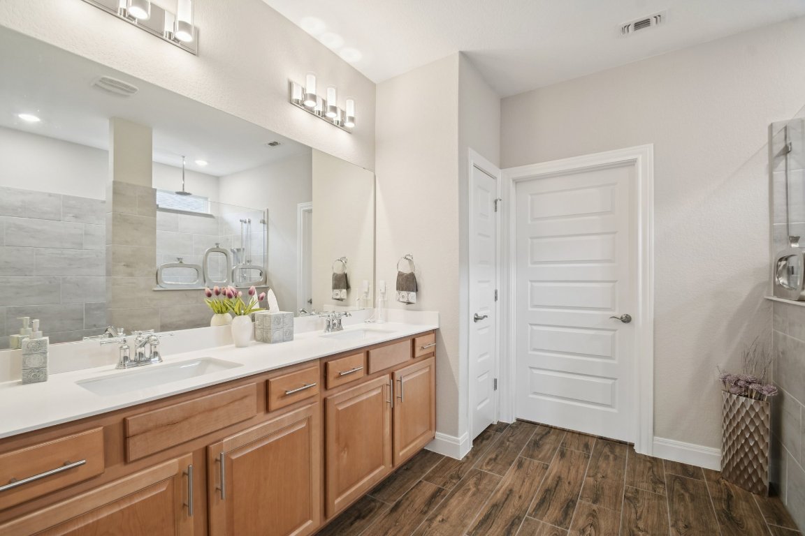 309 Kitty Hawk Road Georgetown, TX 78633 - Photo 22 of 37 a spacious bathroom with a double vanity sink a mirror and a shower