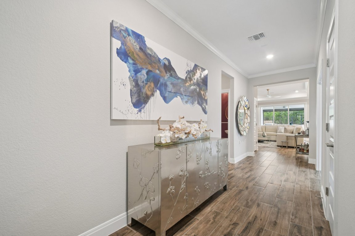 309 Kitty Hawk Road Georgetown, TX 78633 - Photo 5 of 37 a view of a hallway with wooden floor and a couch