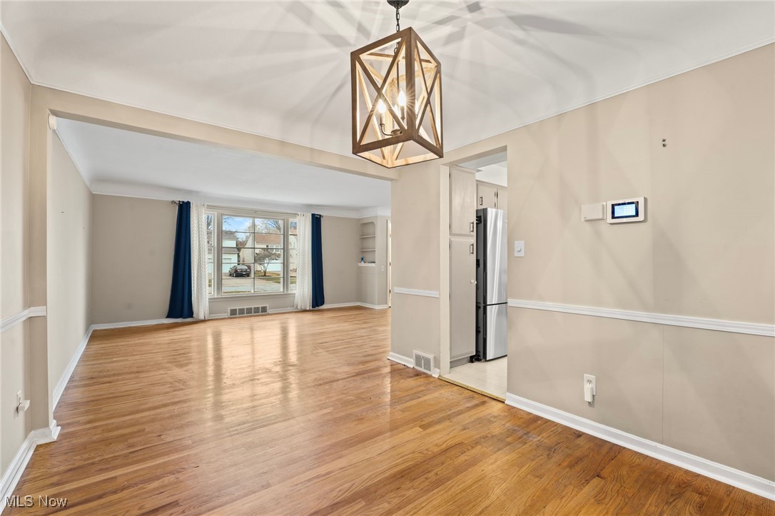 5232 East Farnhurst Road Cleveland, OH 44124 - Photo 8 of 28 Unfurnished dining area with an inviting chandelier and light hardwood / wood-style flooring