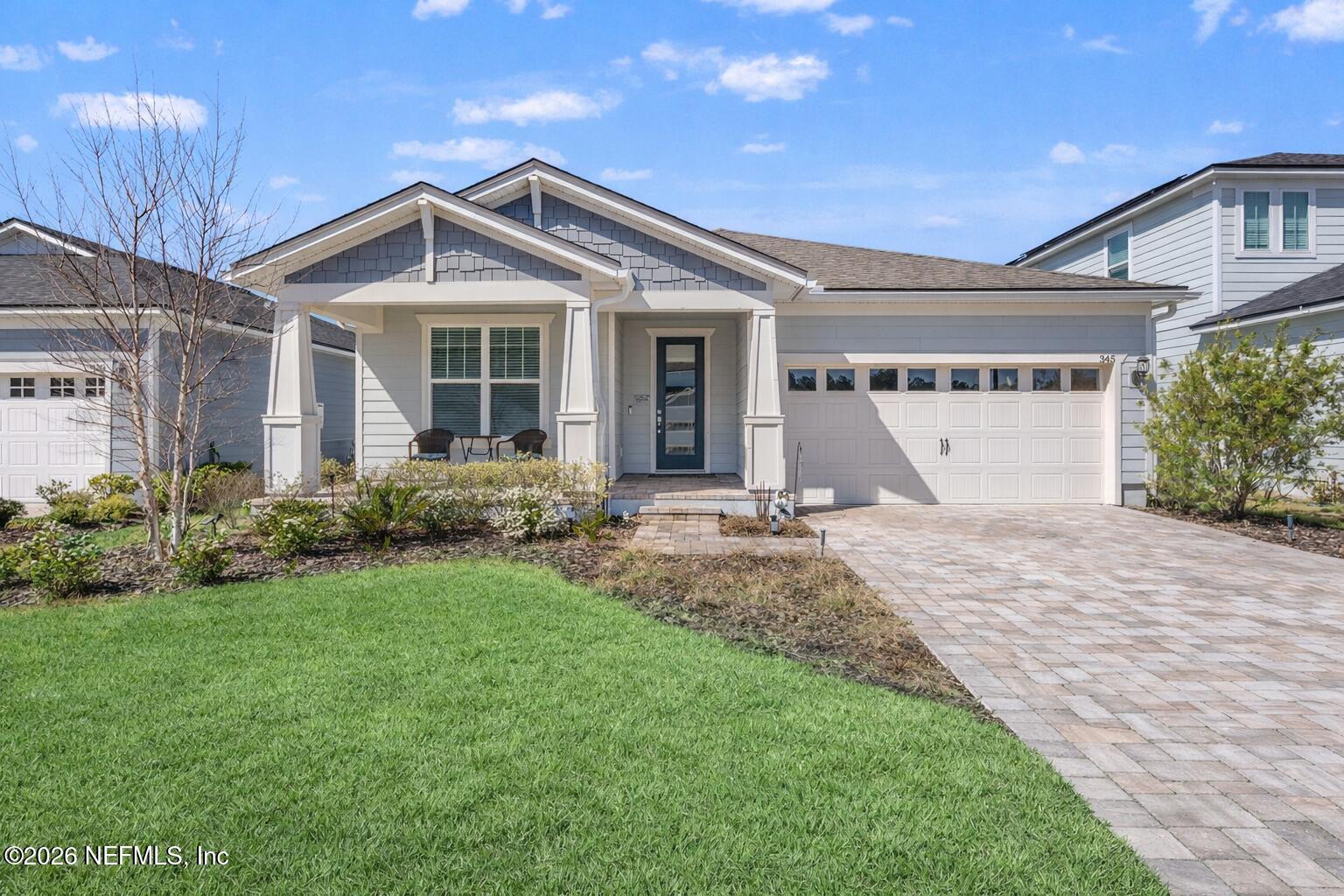 345 Muhly Grass Street Yulee, FL 32097 - Photo 1 of 42 a front view of a house with a yard and garage