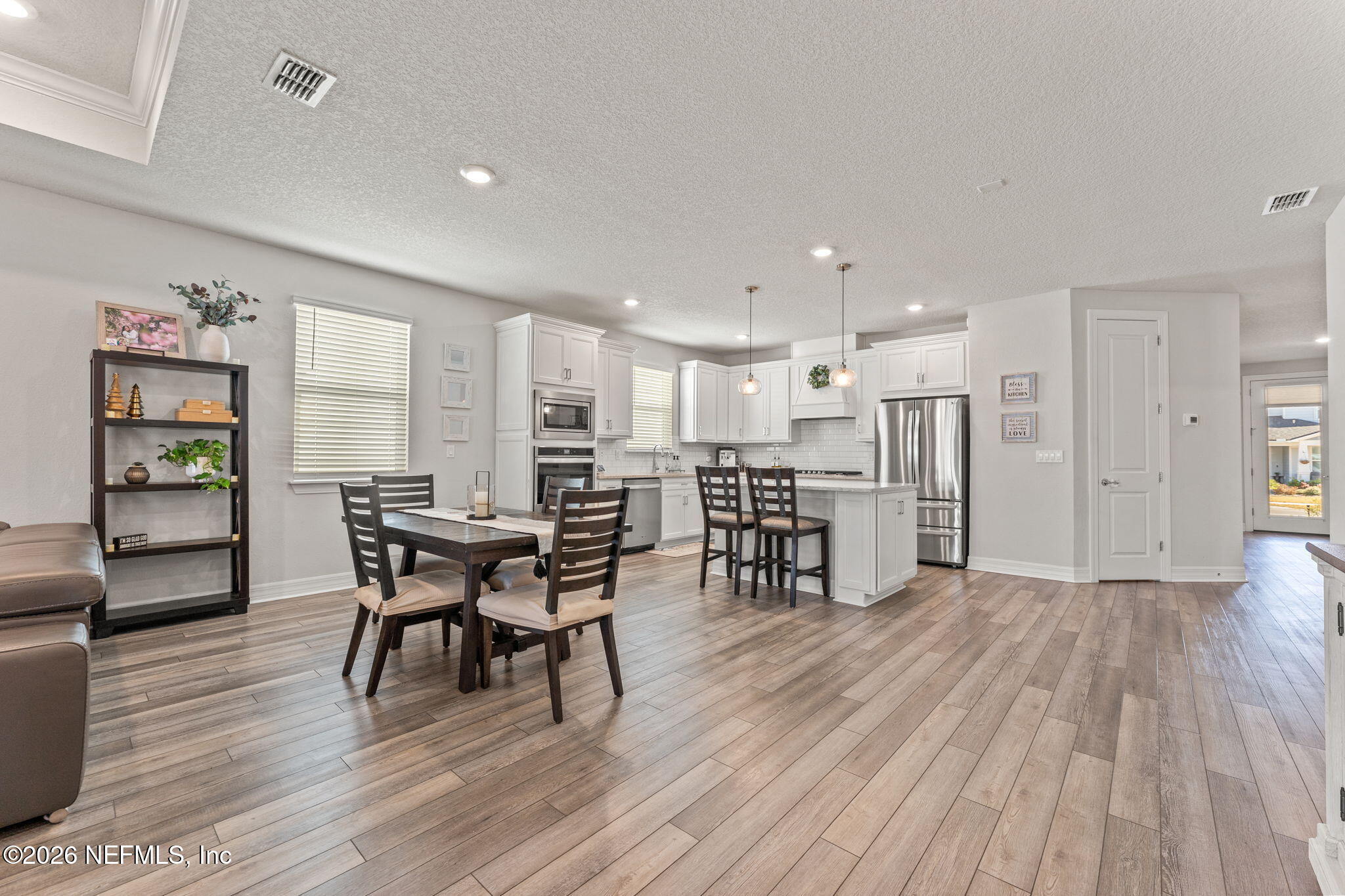 345 Muhly Grass Street Yulee, FL 32097 - Photo 12 of 42 a view of a dining room with furniture and wooden floor