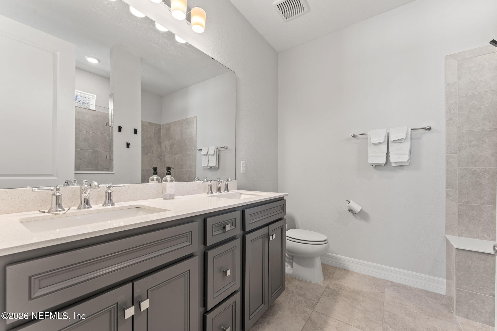 345 Muhly Grass Street Yulee, FL 32097 - Photo 19 of 42 a spacious bathroom with a double vanity sink toilet and a mirror