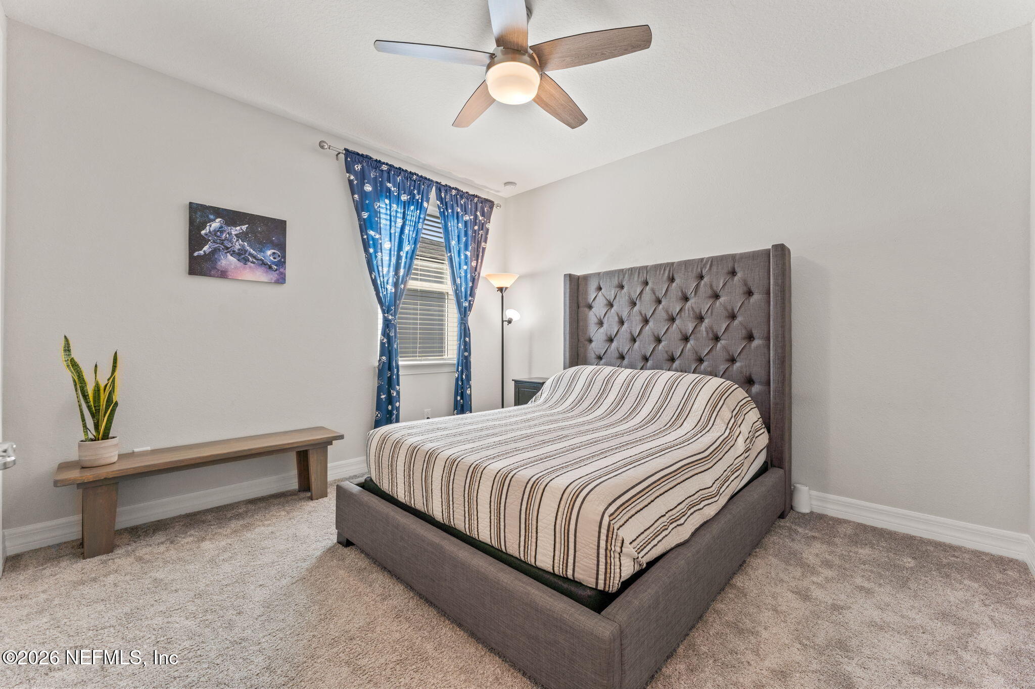 345 Muhly Grass Street Yulee, FL 32097 - Photo 20 of 42 a bedroom with a bed and a chandelier