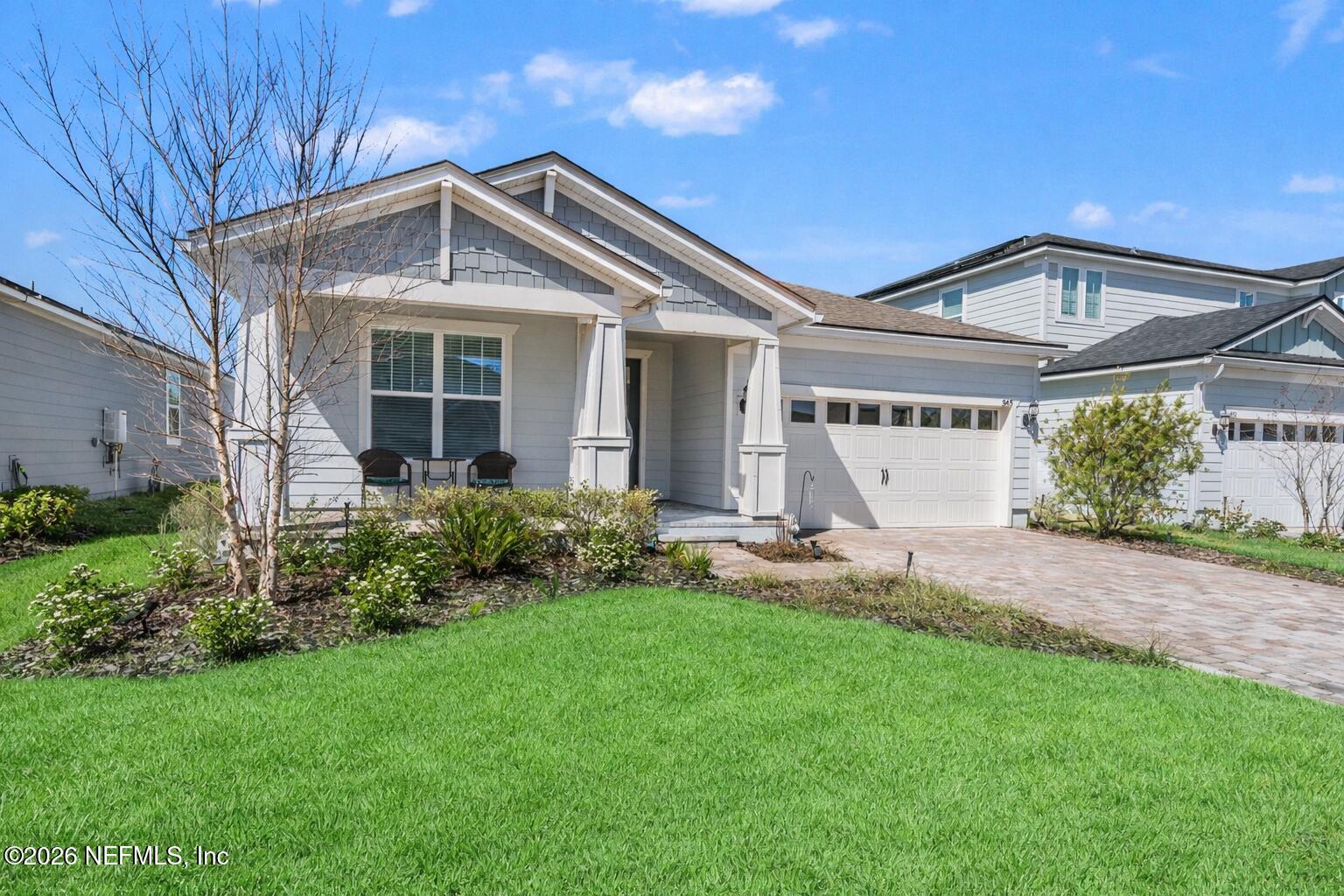 345 Muhly Grass Street Yulee, FL 32097 - Photo 2 of 42 a front view of a house with a garden and plants
