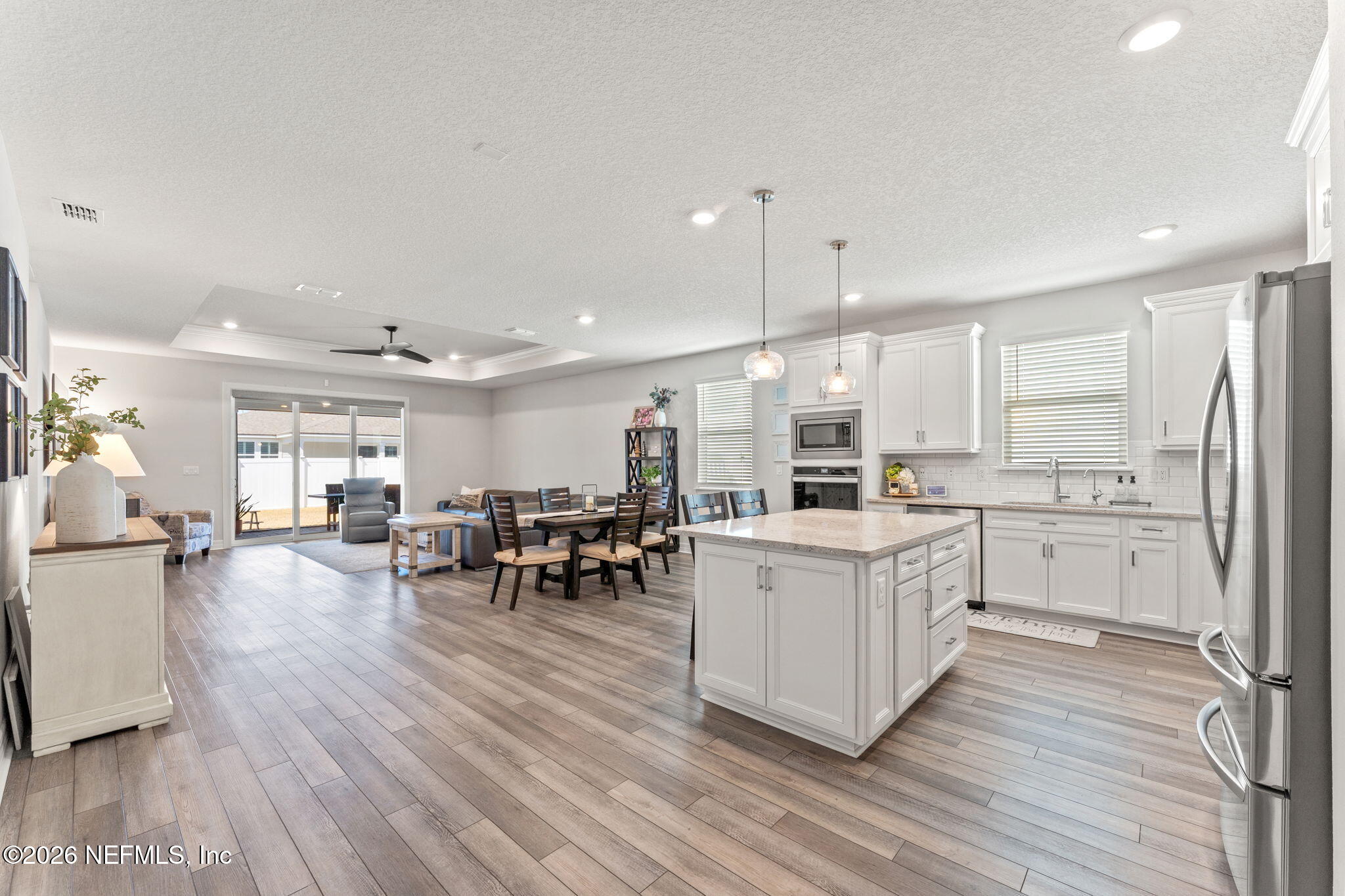 345 Muhly Grass Street Yulee, FL 32097 - Photo 5 of 42 a kitchen with white cabinets and chairs