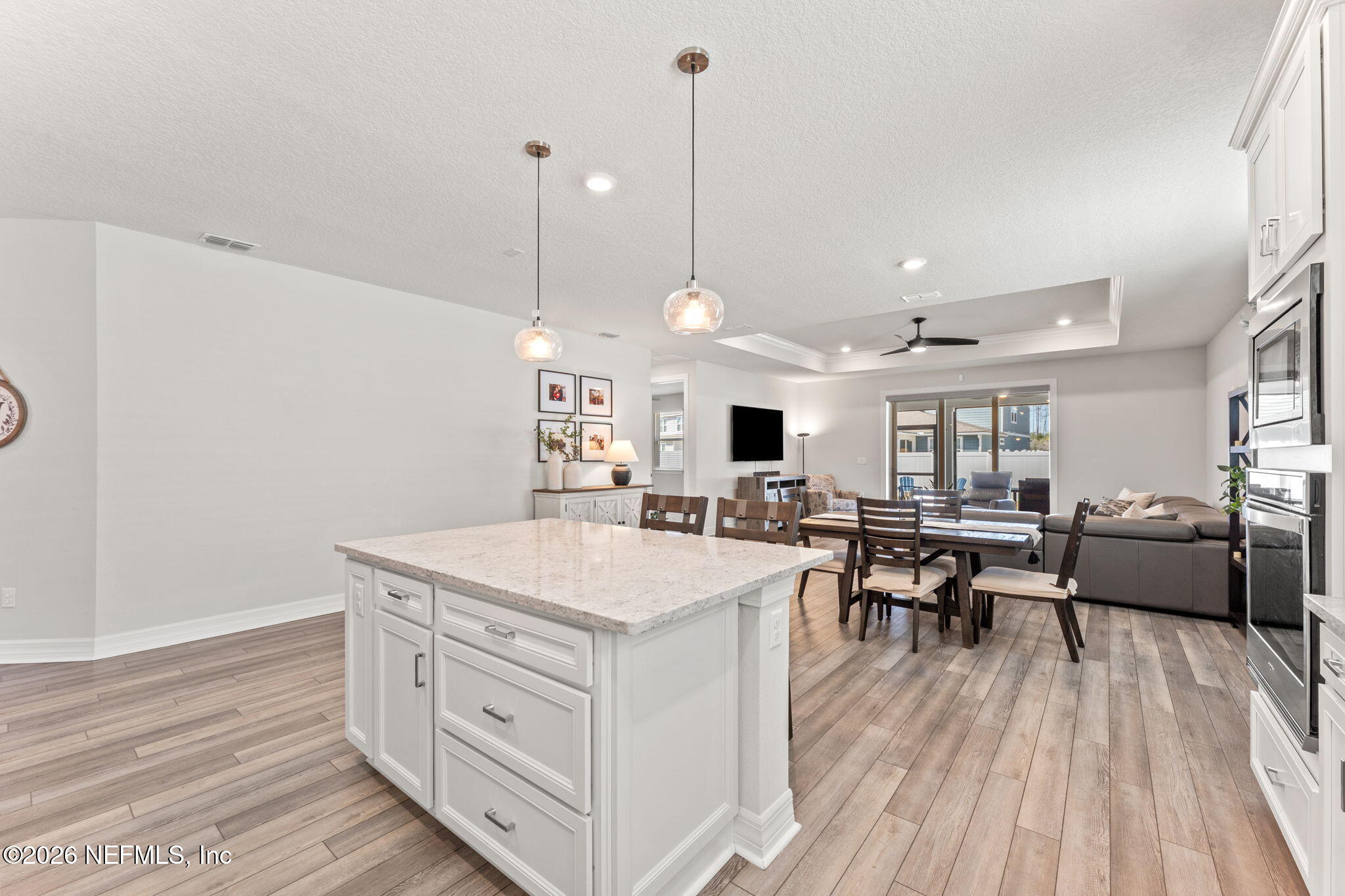345 Muhly Grass Street Yulee, FL 32097 - Photo 6 of 42 a large kitchen with a table chairs and wooden floor