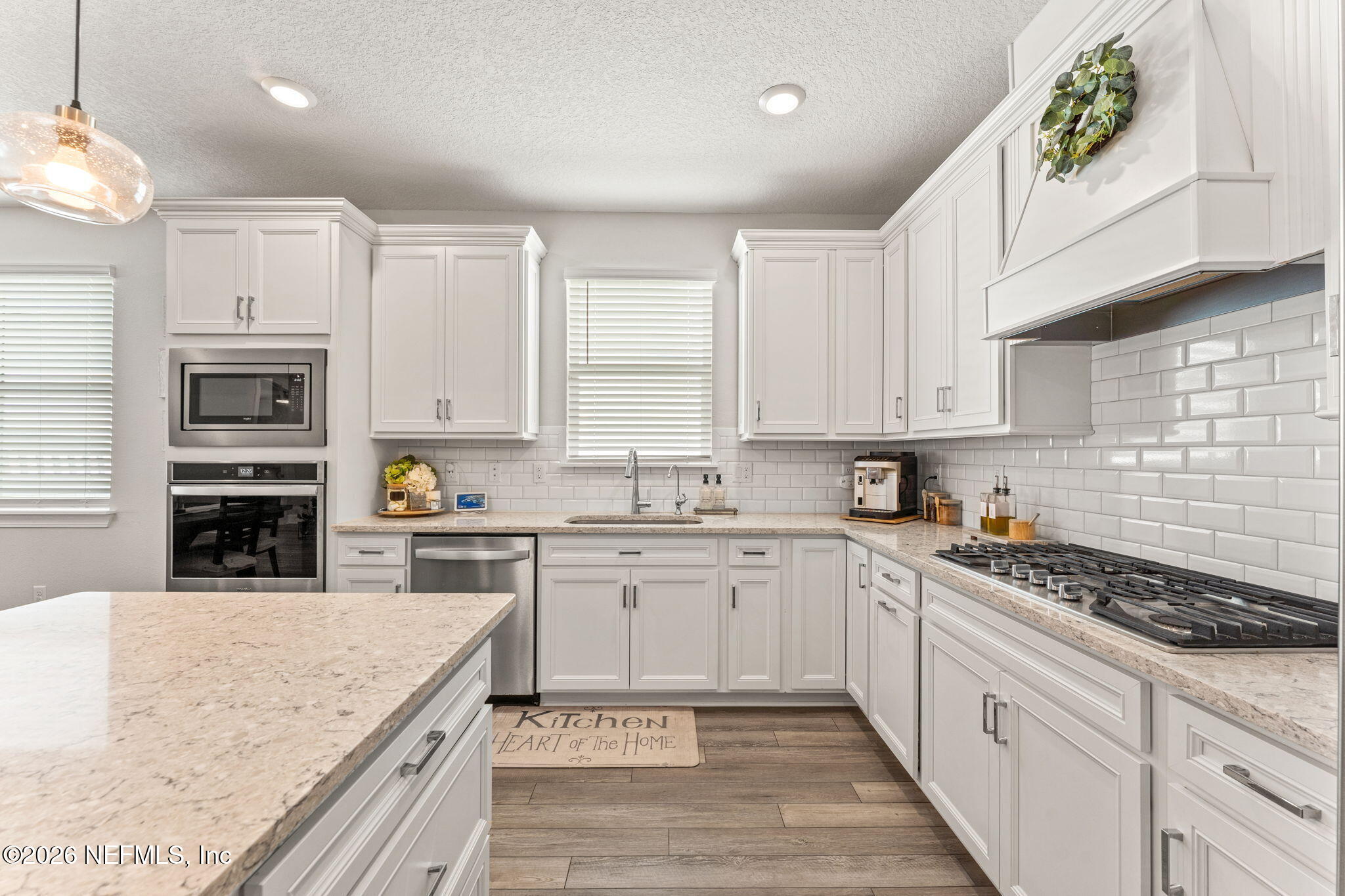 345 Muhly Grass Street Yulee, FL 32097 - Photo 7 of 42 a kitchen with cabinets appliances a sink and a counter top space