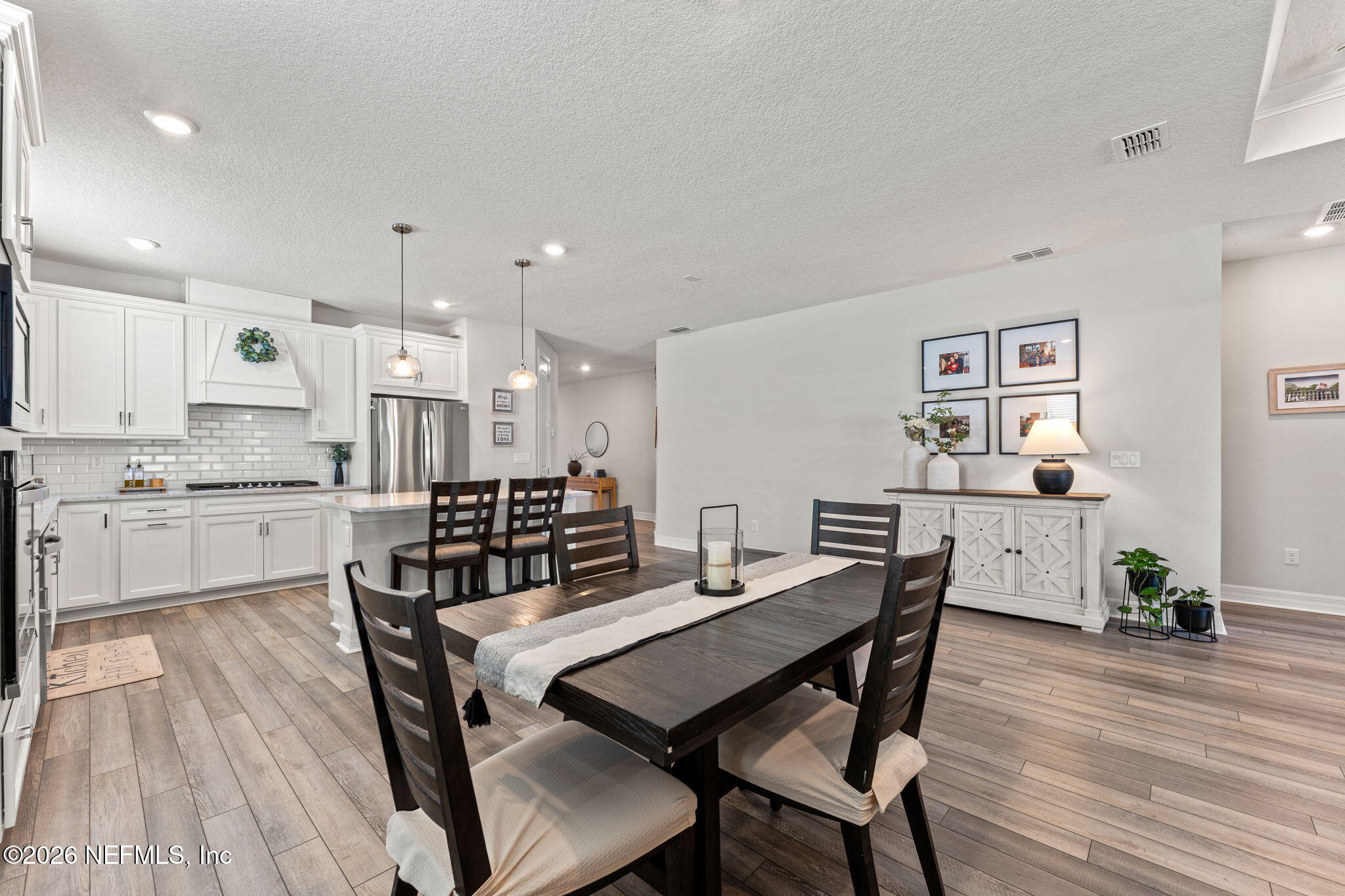 345 Muhly Grass Street Yulee, FL 32097 - Photo 10 of 42 a view of a dining room with furniture and wooden floor