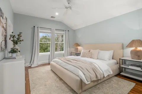 a bedroom with a large bed and a potted plant