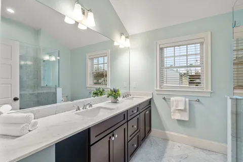 a bathroom with a granite countertop sink a large mirror and a bathtub