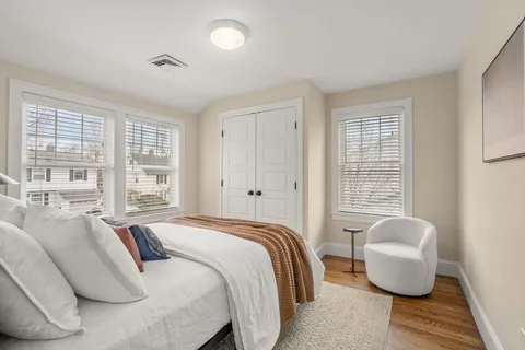 a bedroom with bed couch and window