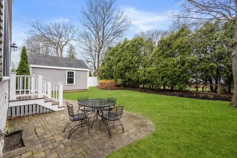 a view of a house with backyard and sitting area