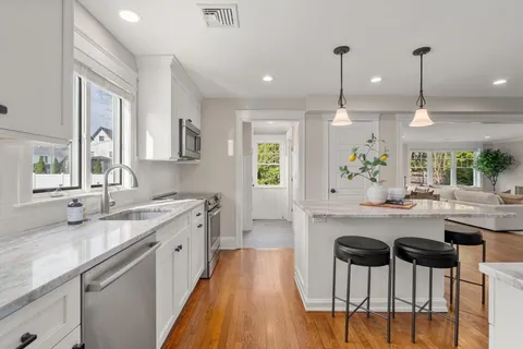 a kitchen with a sink and chairs