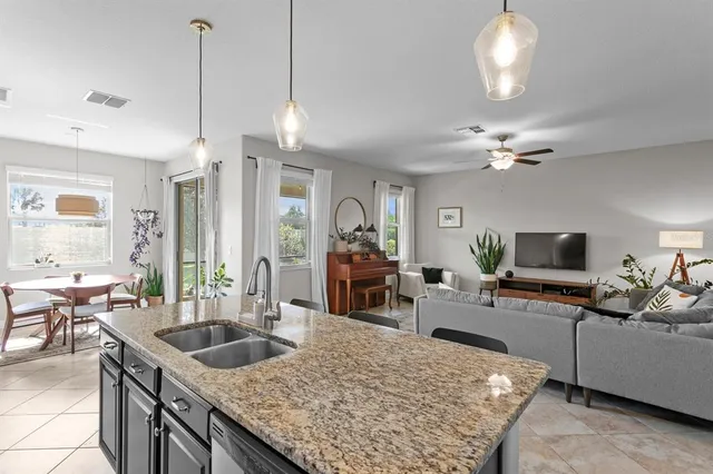 a kitchen with sink stove and living room view