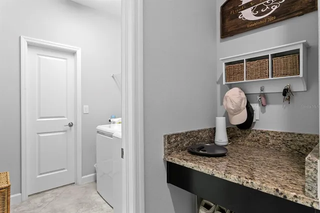a kitchen with a granite countertop sink and white cabinets