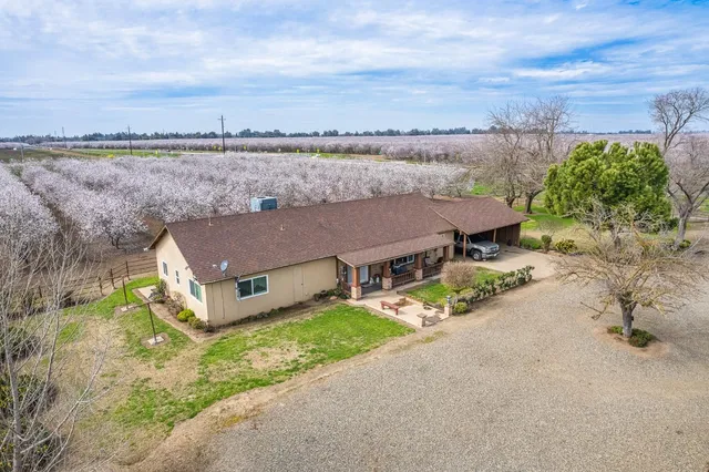 a front view of a house with garden and seating area