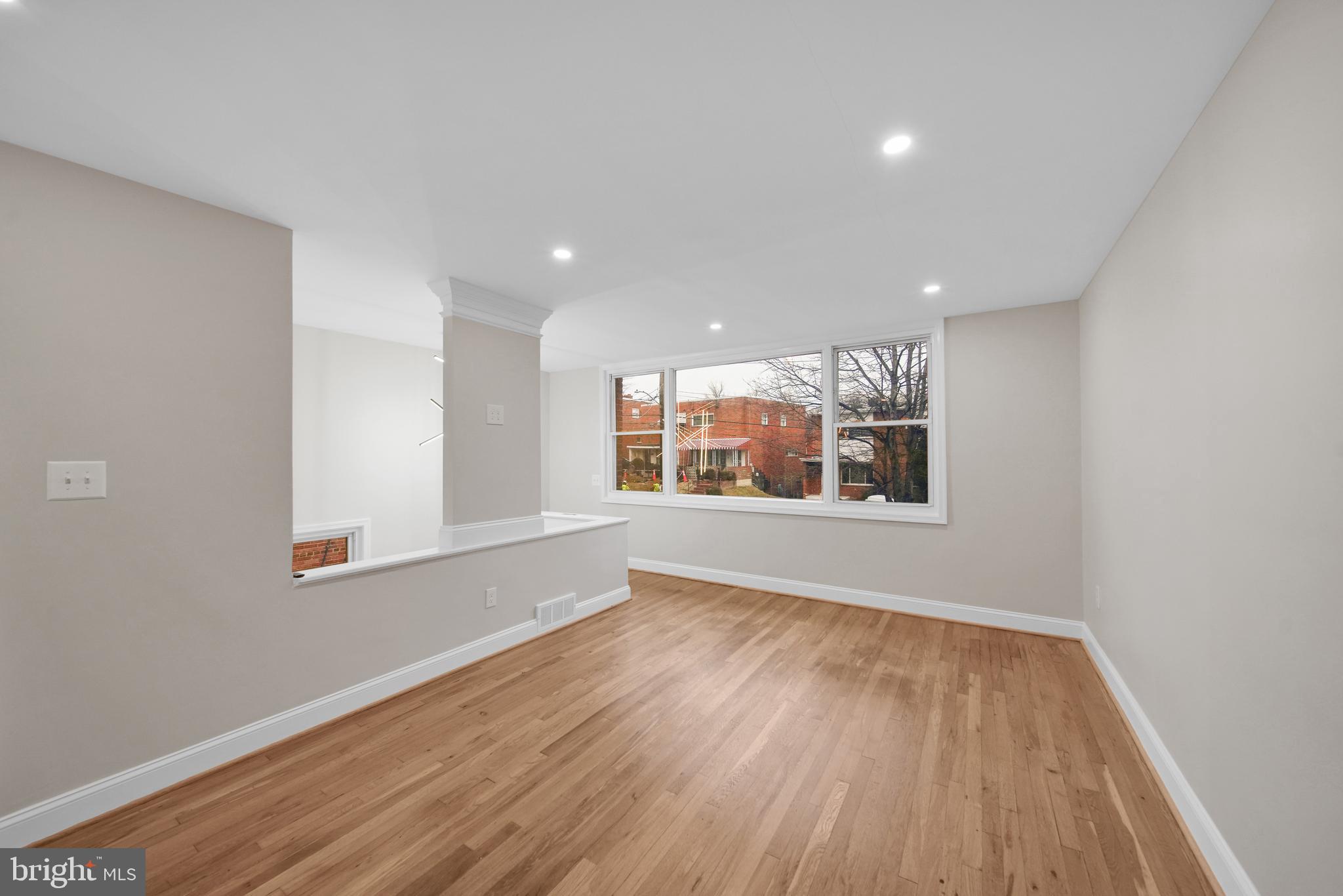 119 Victor Street Northeast, Unit 2 Washington, DC 20011 - Photo 4 of 25 a view of an empty room with wooden floor and a window