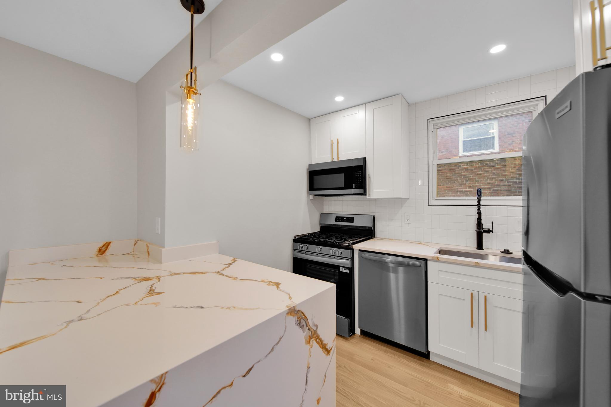 119 Victor Street Northeast, Unit 2 Washington, DC 20011 - Photo 6 of 25 a kitchen with a sink appliances and wooden floor