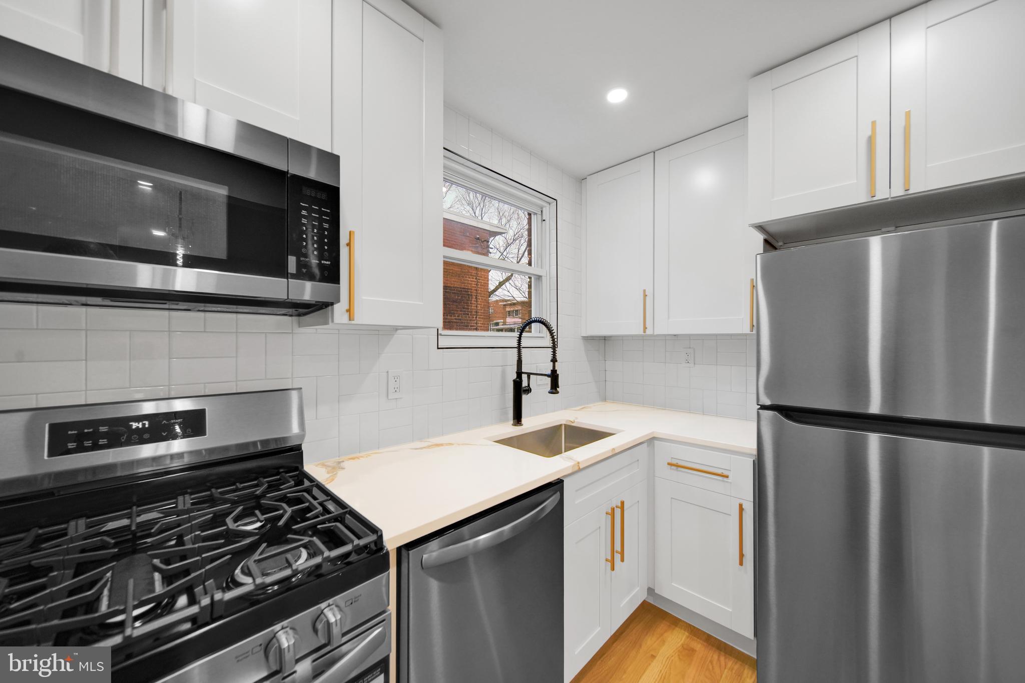 119 Victor Street Northeast, Unit 2 Washington, DC 20011 - Photo 7 of 25 a kitchen with a refrigerator stove and microwave
