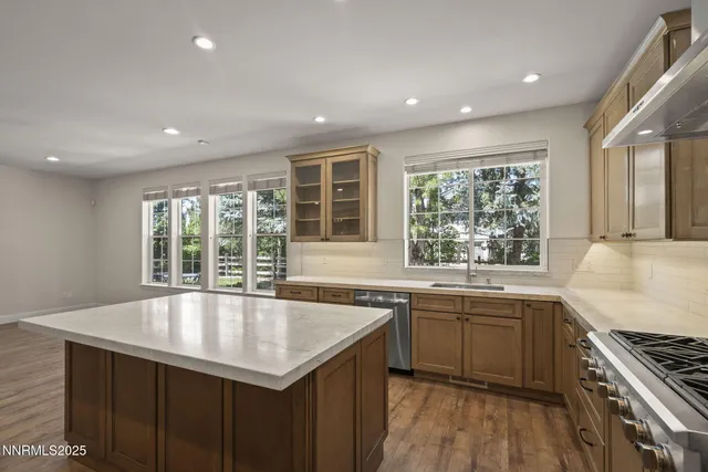 a kitchen with stainless steel appliances granite countertop a sink and dishwasher a oven with wooden floors
