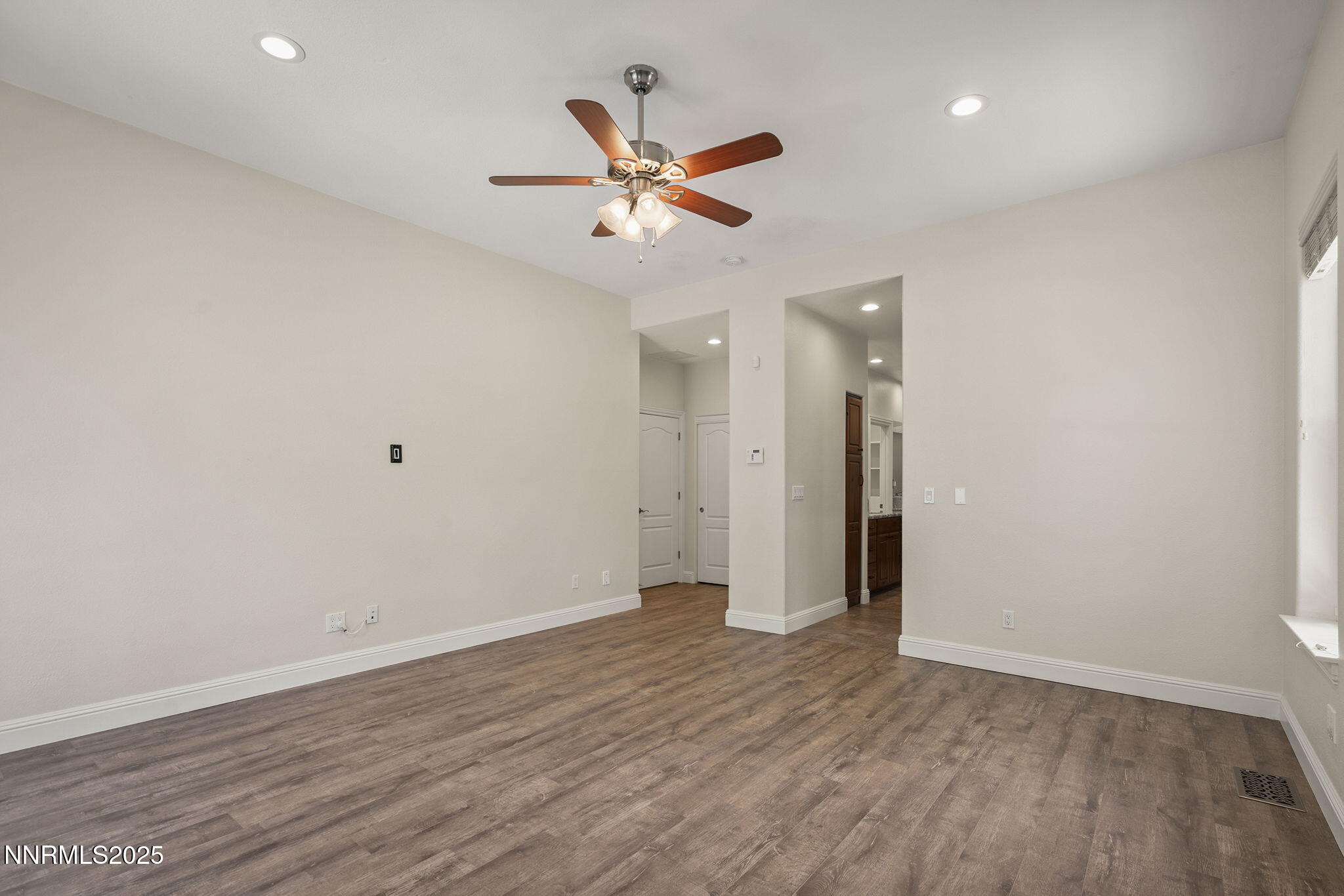 4885 Buckhaven Road Reno, NV 89519 - Photo 23 of 54 a view of an empty room with wooden floor and a ceiling fan