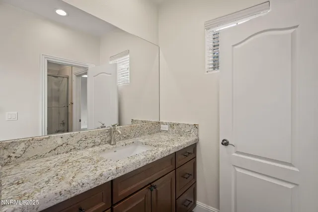 an empty room with wooden floor chandelier fan and windows