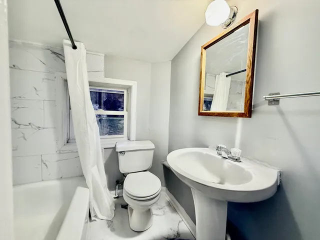 a bathroom with a sink toilet and shower